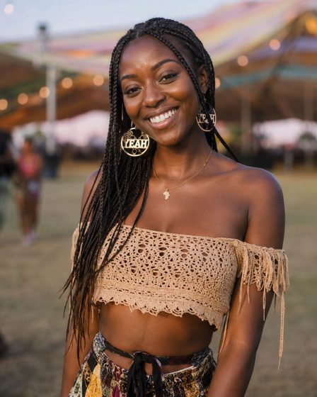 The reference photo: Maya at a festival, smiling, with long braids and gold hoop earrings.