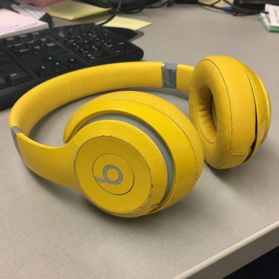 The reference photo: big yellow over-ear headphones on a desk.