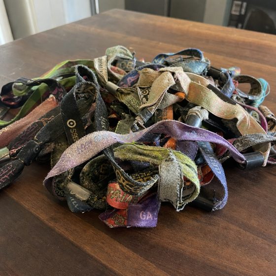The reference photo: a heap of cut-off festival wristbands on a kitchen table.